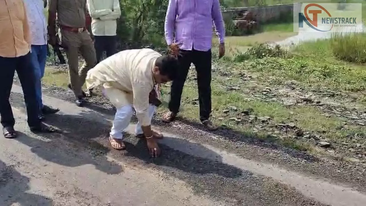 हरदोई के विधायक प्रभाष कुमार सड़क पर हाथ लगाकर उसकी गुणवत्ता जांचते हुए, पास में अधिकारी और ग्रामीण खड़े हैं।