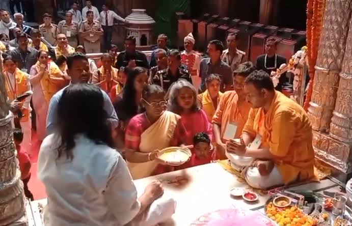 President Droupadi Murmu receiving a religious memento and blessings during her visit to Vrindavan temples