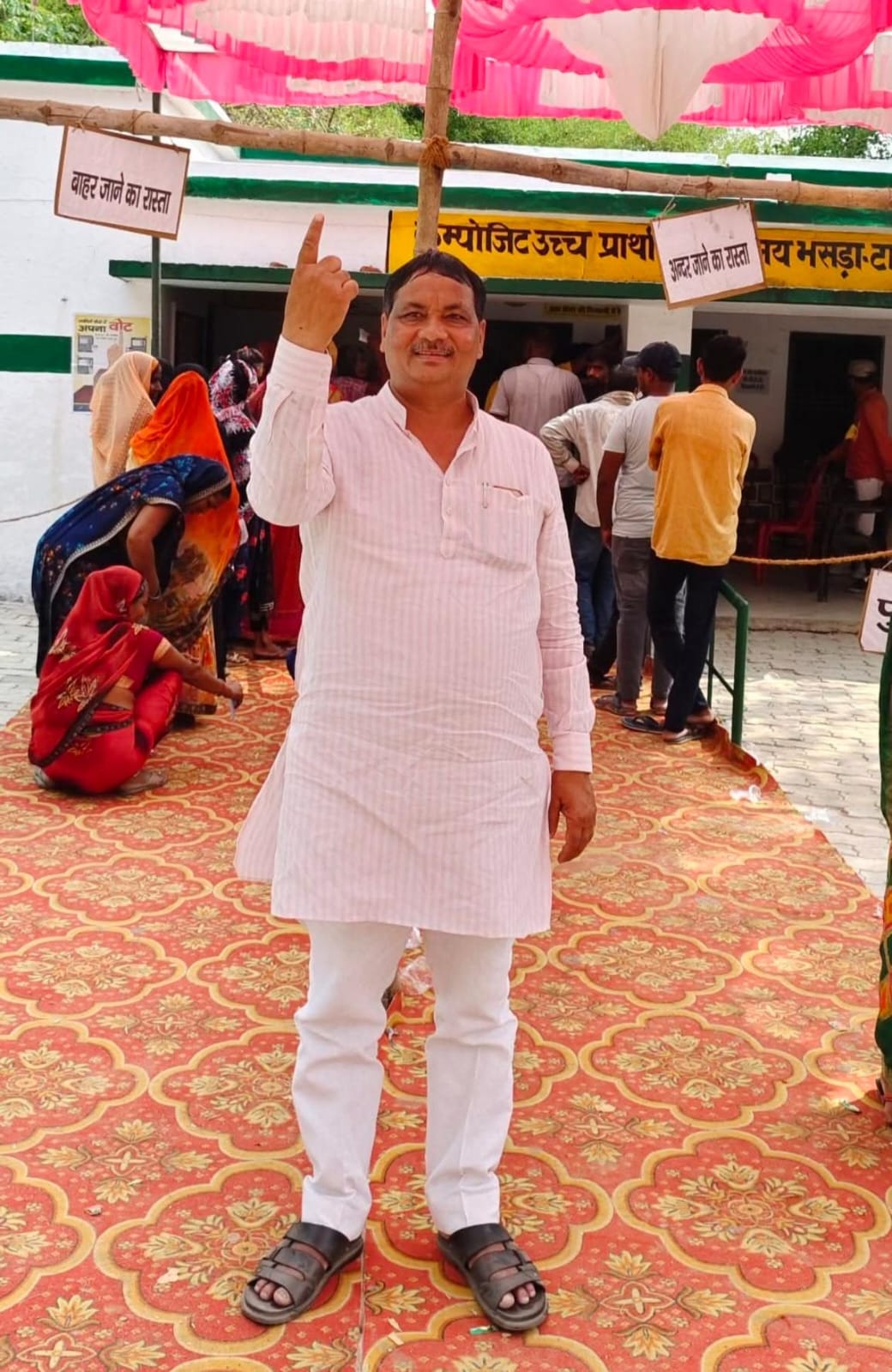 श्याम सुंदर वर्मा मतदान के बाद स्याही लगी उंगली दिखाते हुए, अंबेडकर नगर जिला पंचायत चुनाव 2025