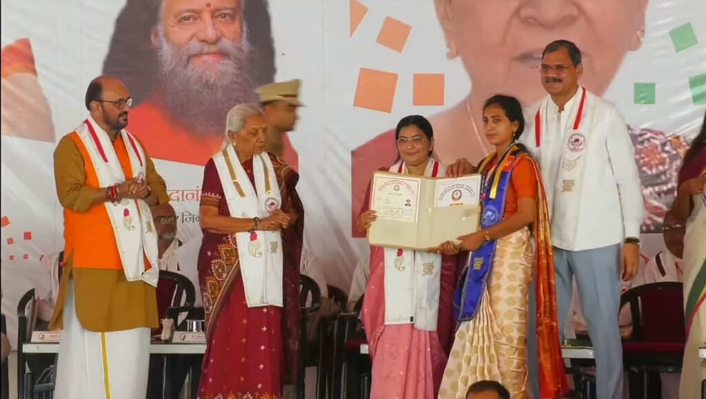 गरिमा पाल श्यामा तिवारी महाविद्यालय तिनहरी परसूपुर मऊ की छात्रा, महाराजा सुहेलदेव विश्वविद्यालय आजमगढ़ के द्वितीय दीक्षांत समारोह में गोल्ड मेडल और कुलपति मेडल प्राप्त करते हुए, मंच पर विश्वविद्यालय के वरिष्ठ अधिकारी और शिक्षक मौजूद हैं।