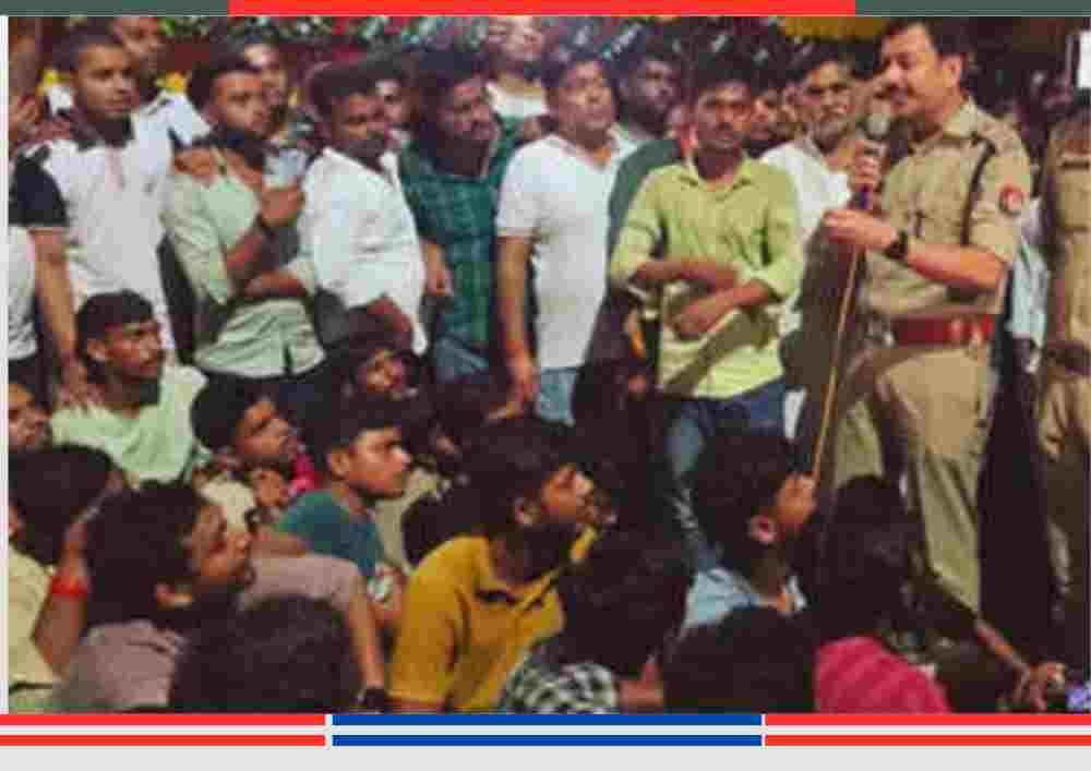 बलिया दुर्गा पंडाल विवाद के दौरान पुलिस अधिकारी प्रदर्शनकारियों से बातचीत करते हुए