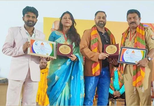 नई दिल्ली में आयोजित गाँधी पीस इंटरनेशनल अवार्ड समारोह में सब इंस्पेक्टर अनूप मिश्रा और शिक्षिका डॉ. रचना सिंह को सम्मानित करते हुए अभिनेता सुमित मलाहान और आयोजक अमोल भगत