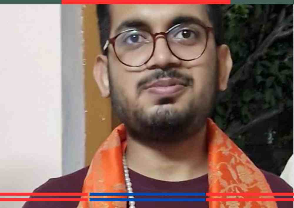 देवांश खोसला, चश्मा पहने, गले में भगवा दुपट्टा और मुस्कान के साथ, RAS परीक्षा में 86वीं रैंक प्राप्त करने के बाद