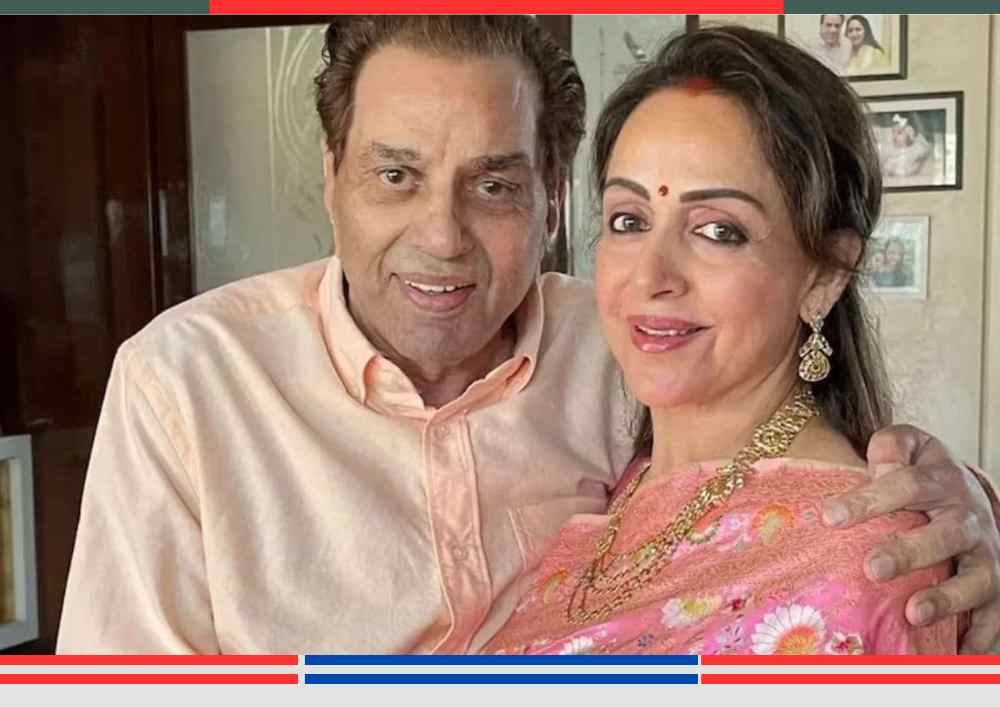 धर्मेंद्र और हेमा मालिनी की ताज़ा तस्वीर, जिसमें दोनों मुस्कुराते हुए कैमरे की ओर देख रहे हैं — झूठी मौत की खबरों के बीच अभिनेता धर्मेंद्र का जीवंत संदेश।