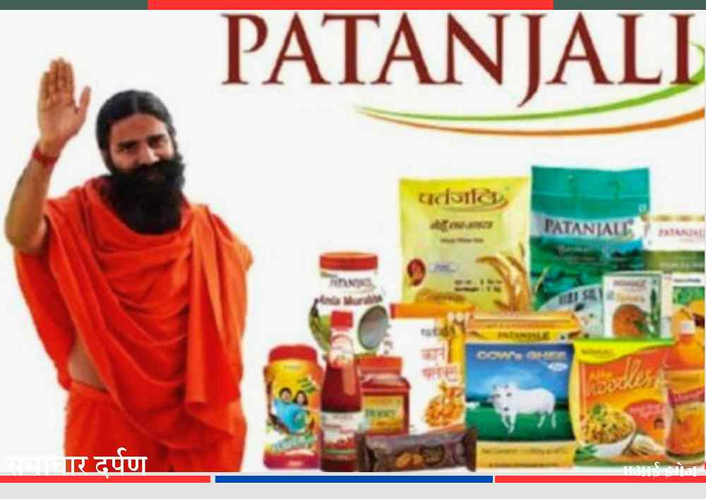 पतंजलि ब्रांड के खाद्य एवं आयुर्वेदिक उत्पादों के साथ एक योग गुरु हाथ उठाकर अभिवादन करते हुए।