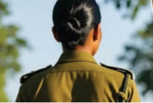 पीठ से दिखाई देती महिला सिपाही की वर्दीधारी तस्वीर, जो पुलिस विभाग में महिला कर्मियों से जुड़े संवेदनशील मामले का प्रतीकात्मक दृश्य दर्शाती है