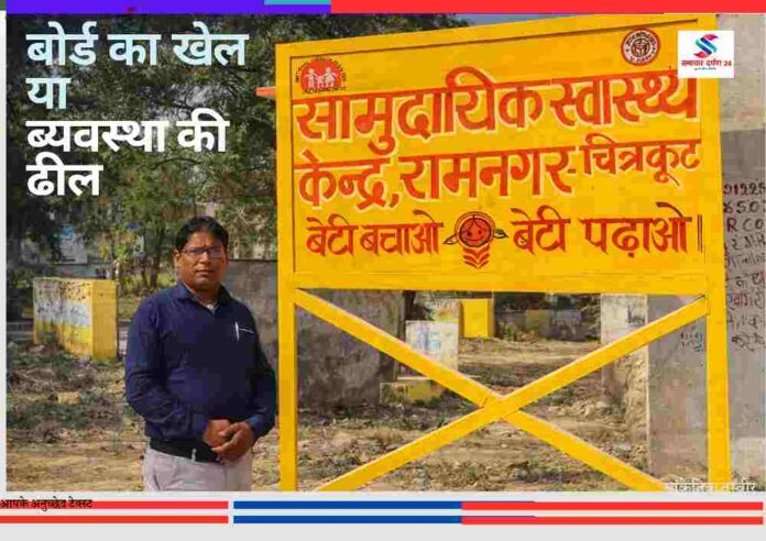 चित्रकूट के रामनगर सामुदायिक स्वास्थ्य केंद्र के बोर्ड के पास खड़े व्यक्ति की तस्वीर, जहां बोर्ड विवाद को लेकर सवाल उठ रहे हैं