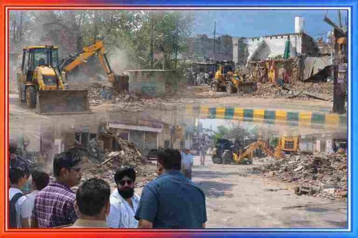 सीतापुर में प्रशासन द्वारा अतिक्रमण हटाने के दौरान बुलडोजर से अवैध निर्माण तोड़ते हुए, मलबे के बीच खड़े लोग और सुरक्षा में तैनात पुलिस